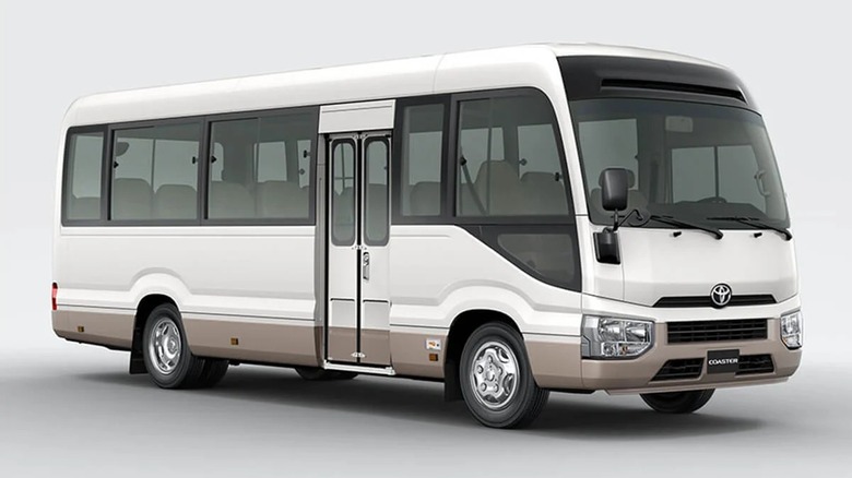 Front 3/4 view of a new Toyota Coaster, two-tone white over bronze exterior