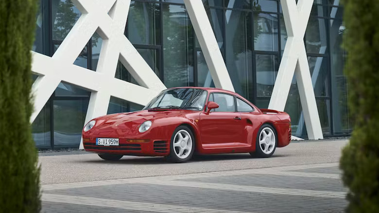 Red Porsche 959 parked in front of a building