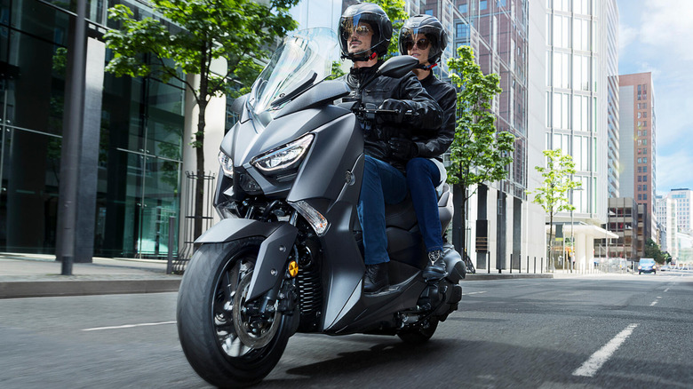 Rider with a passenger cruising on a 2020 Yamaha XMAX 400 in city streets