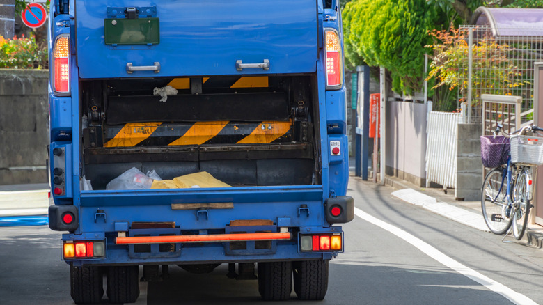 Close-up view of the back of the open back of a garbage truck.