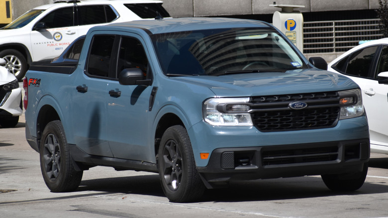 A blue Ford Maverick pick-up truck cruising in the downtown financial district of Houston