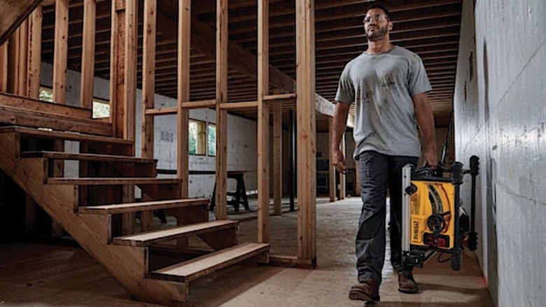 Person carrying compact DeWalt Table Saw