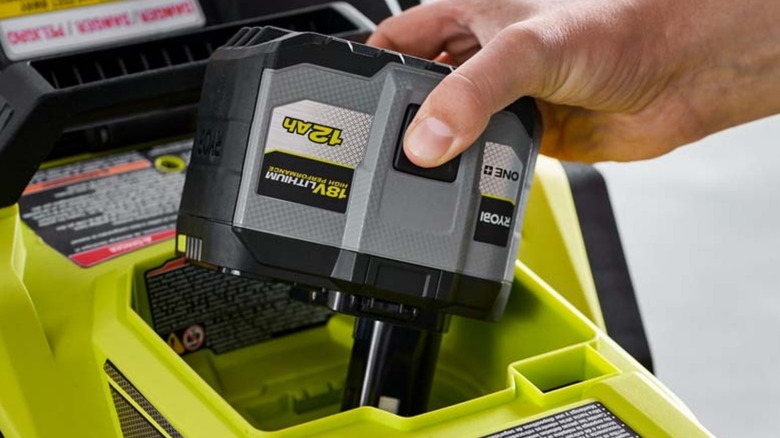 Person plugging in Ryobi 12 Ah battery