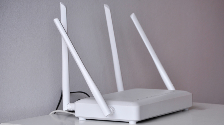 A white router sitting on a white desktop
