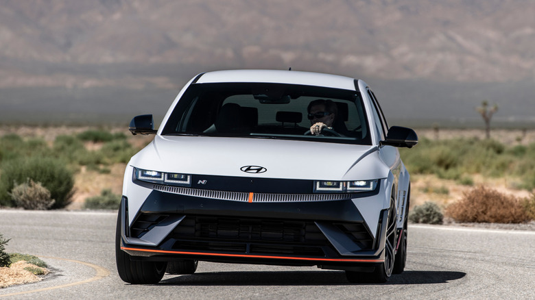 Front view of  man driving white 2025 Hyundai Ioniq 5N on desert road