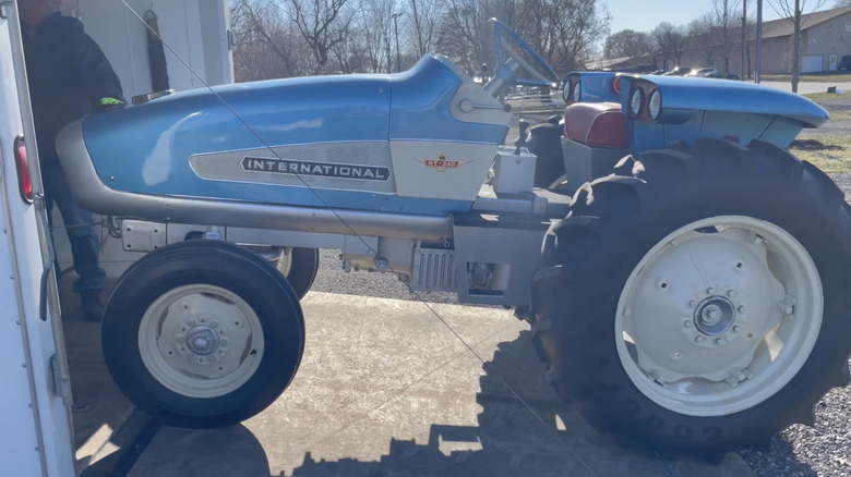 Blue and silver Tractor from International Harvester being loaded onto a van.