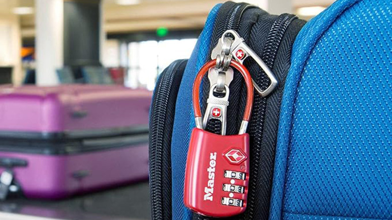 Master Lock TSA approved lock securing luggage on airport carousel