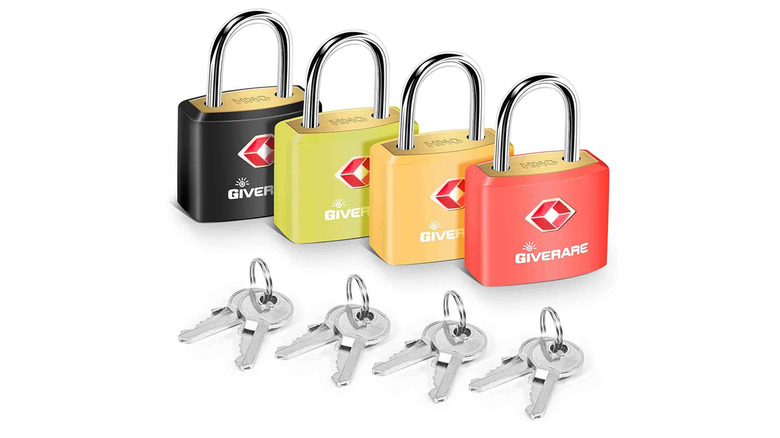 Four TSA approved locks and keys on plain background