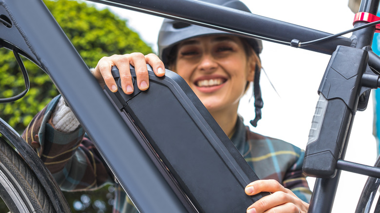 Woman holding battery pack e-bike