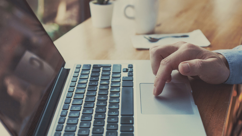 Person's finger on laptop trackpad