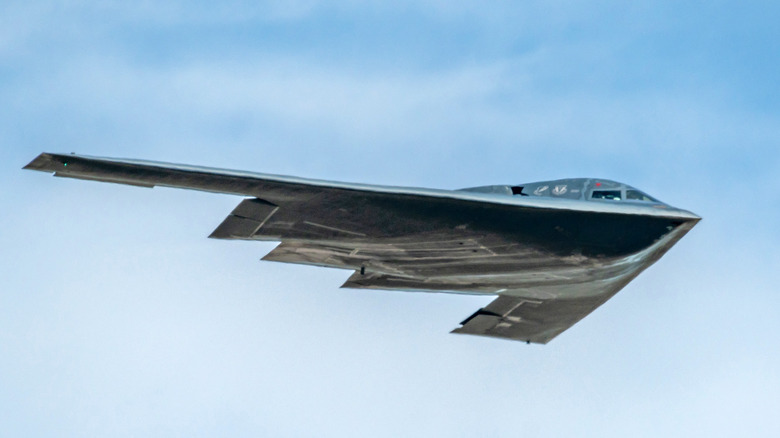 a stealth b2 bomber in flight against a cloudy sky