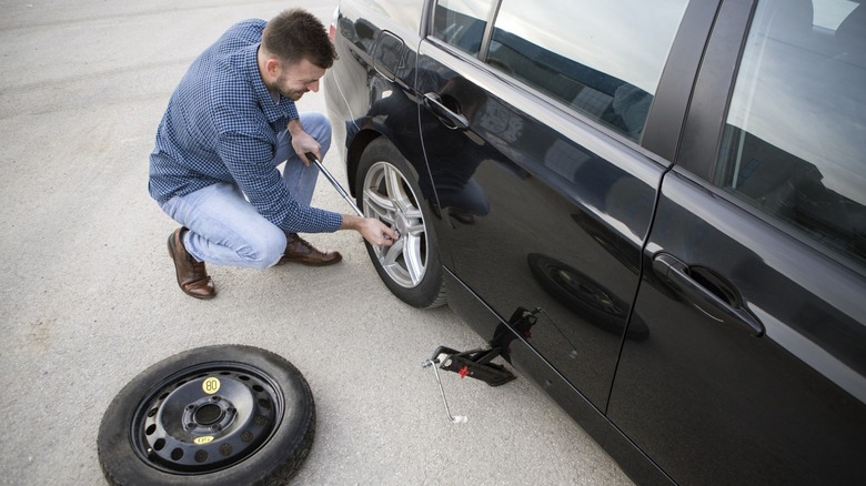 Changing flat tire with spare tire