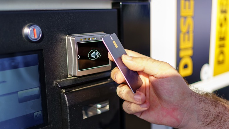 Paying for gas at the pump with a credit card.