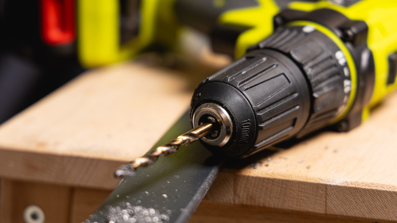 Close-up of a drill resting on a bench.