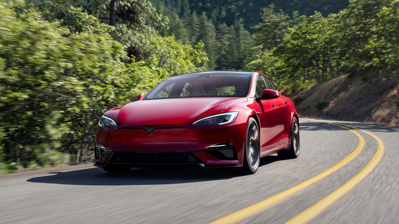 A 2026 Tesla Model S in red on the move, front 3/4 view