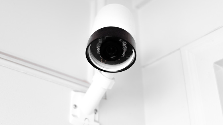 Close-up of outdoor security camera mounted above front entry to private residence
