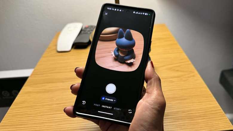 An Android phone has the Instagram Instant camera page open and taking a photo of a toy