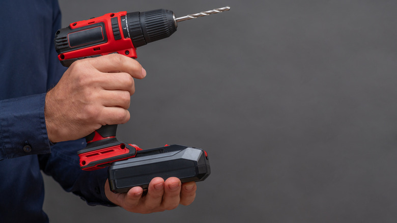 Hand inserting power tool battery into drill