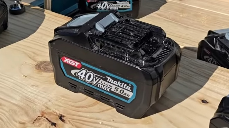 Makita XGT batteries on a table outside.