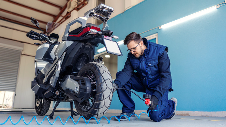 Man checking motorcyle tires
