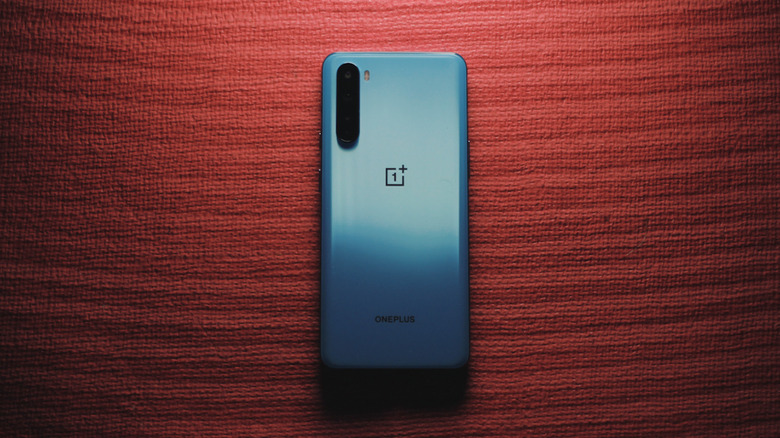 A blue OnePlus Nord on a red craft paper