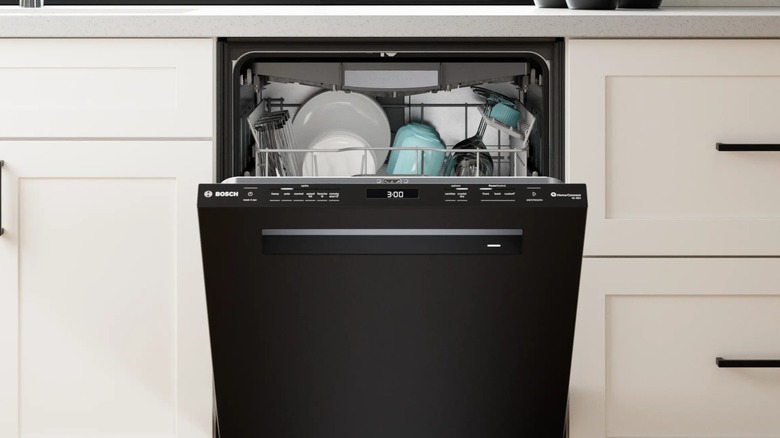 A half-opened Bosch dishwasher built into the kitchen cabinets.