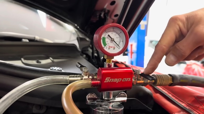 A mechanic bleeding the coolant system of air pockets when adding new fluid