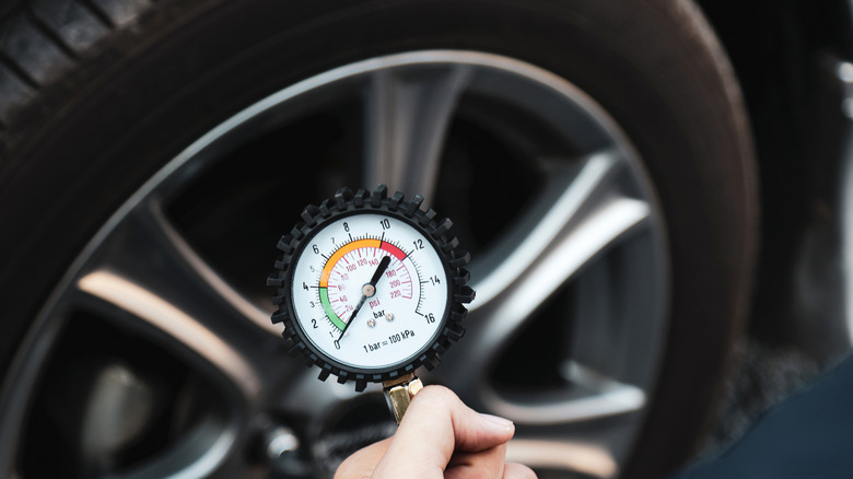 Mechanic holding a tire pressure gauge