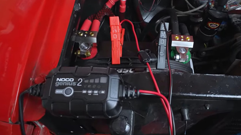 Trickle charger attached to a car battery charger in engine bay