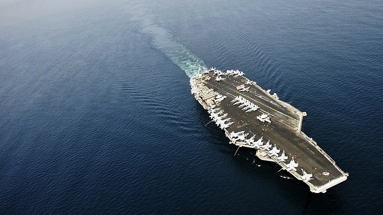The aircraft carrier USS Harry S. Truman (CVN 75) transits in the Arabian Sea as Sailors on the flight deck prepare for the morning flight operations cycle.