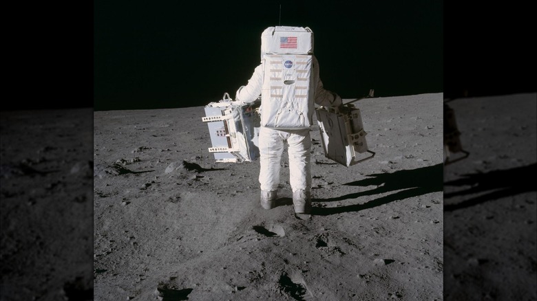 Astronaut Edwin E. Aldrin Jr., lunar module pilot, walking on the Moon to place the Laser Ranging Retro-Reflector (LR3) in 1969.,