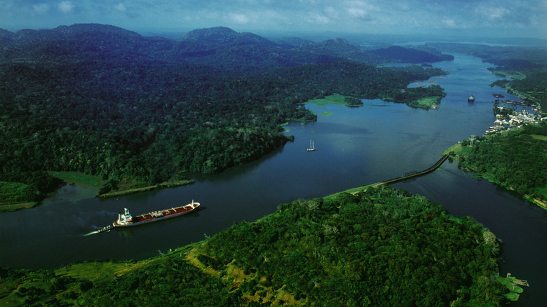 A large ship traveling through a wide section of the Panama Canal.