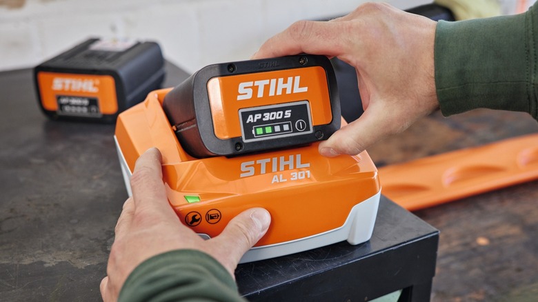 Stihl AL 301 charger charging AP 300 S battery with other Stihl battery in the background