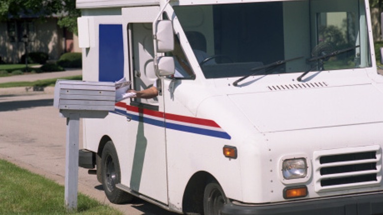 Postal worker delivers mail in truck
