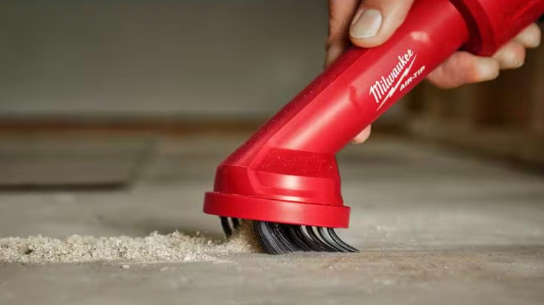 Close-up of a Milwaukee Air-Tip Cross Brush Tool sucking up dust