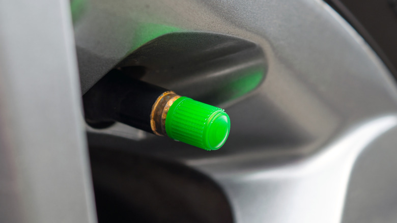 A green valve cap on a tire highlighting that it's filled with nitrogen