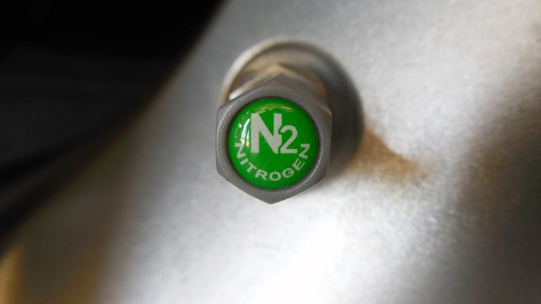 A green valve cap on a wheel with the words 