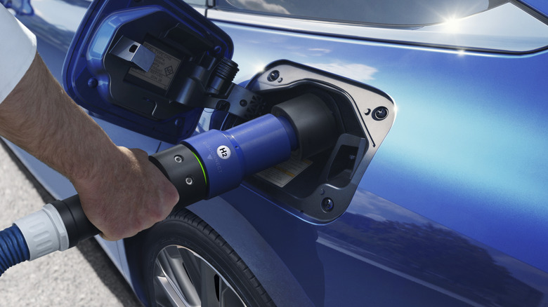 A person refueling a Toyota Mirai with hydrogen