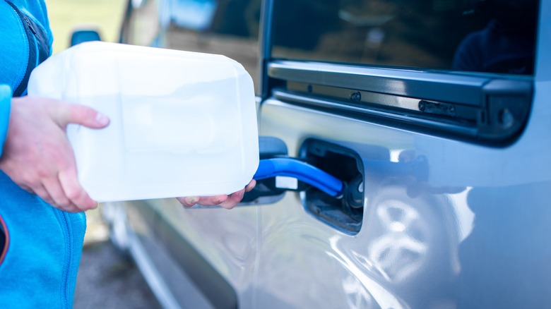 Person filling his car with Diesel Exhaust Fluid, also known as AdBlue