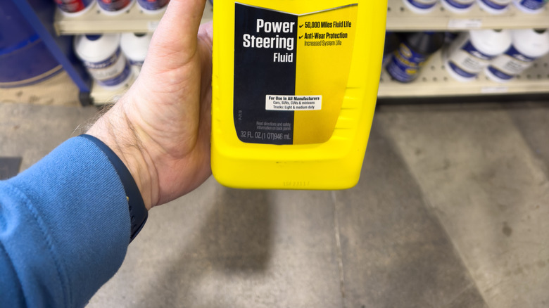 Container of Prestone power steering fluid in front of shelves of similar products