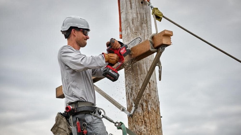 Working on a utility pole with a Milwaukee M18 Fuel Hatchet 8 inch pruning saw