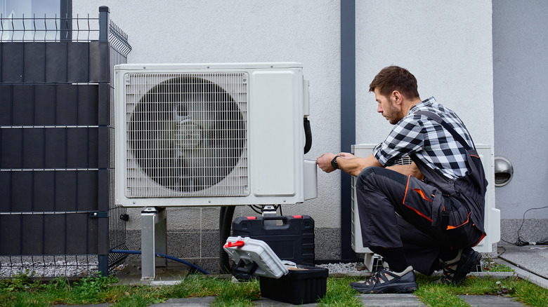 Person inspecting a new HVAC heat pump