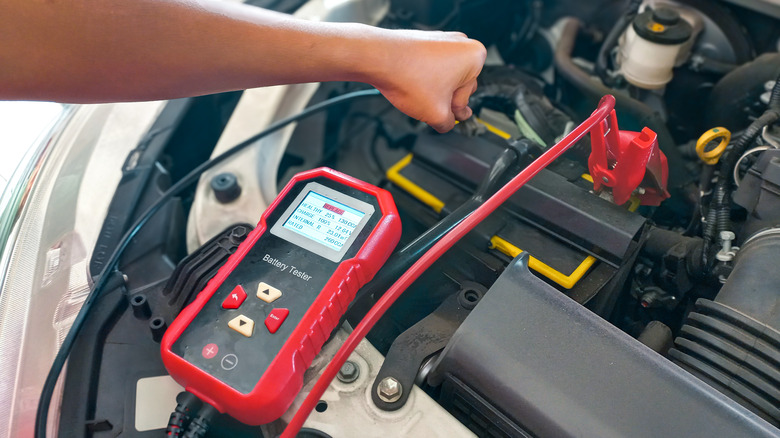 Person testing a battery with a battery tester