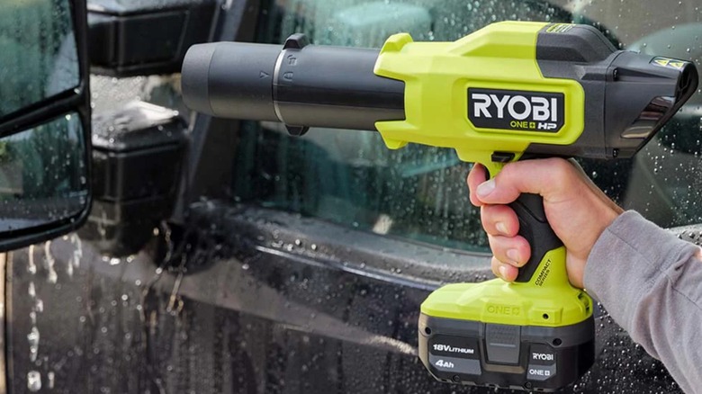 person using 18V ONE+ HP Compact 220 CFM Blower on car