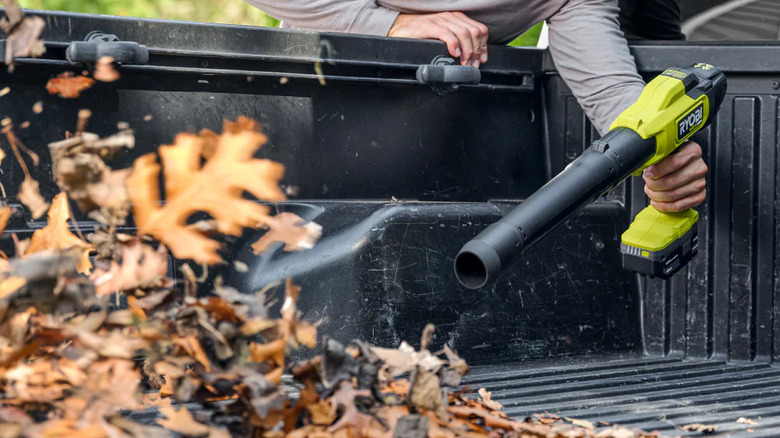 man using Ryobi compact leaf blower on truck bed