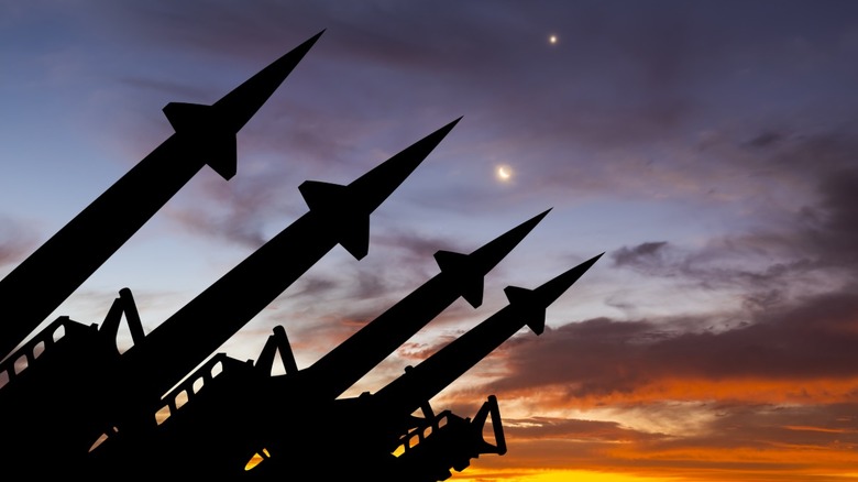 Several missiles lined up with a sunset background