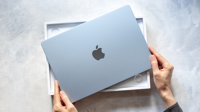 Picture of a blue MacBook Air over its box on a flat surface
