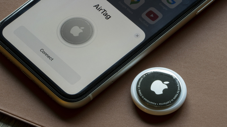 An AirTag is seen being connected to an iPhone
