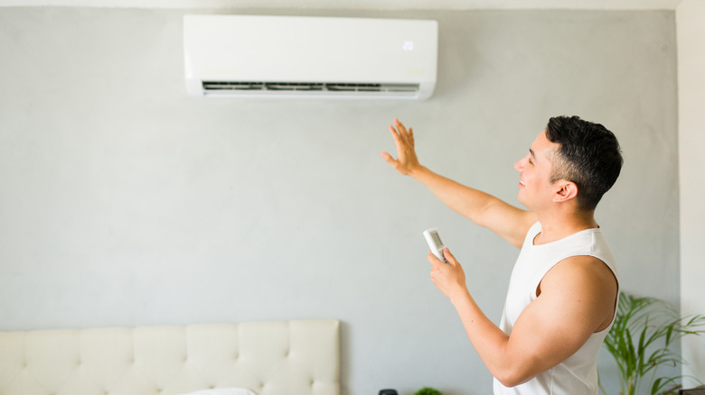 Man powering on mini split air conditioner