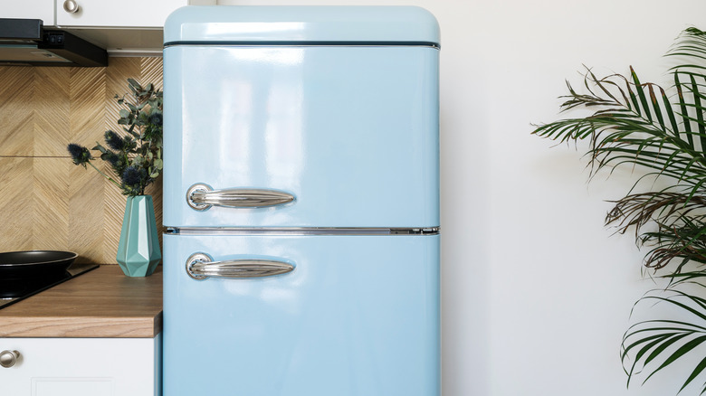 A modern kitchen with a small, retro-style blue refrigerator